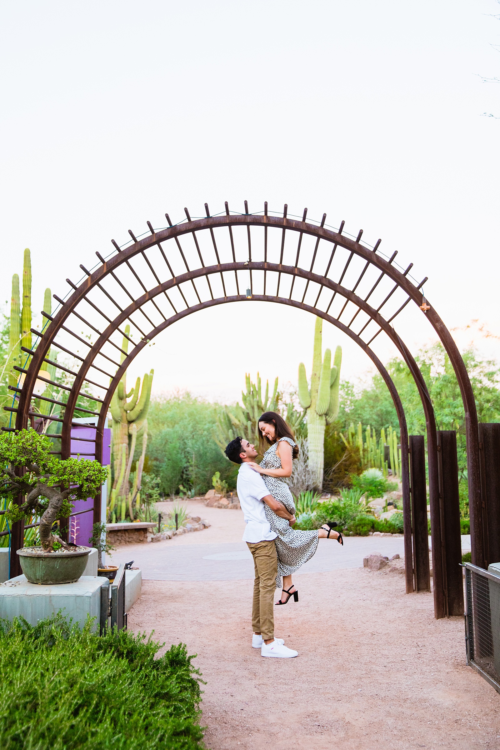 Couple having fun together during their Desert Botanical Garden engagement session by Phoenix engagement photographer PMA Photography.
