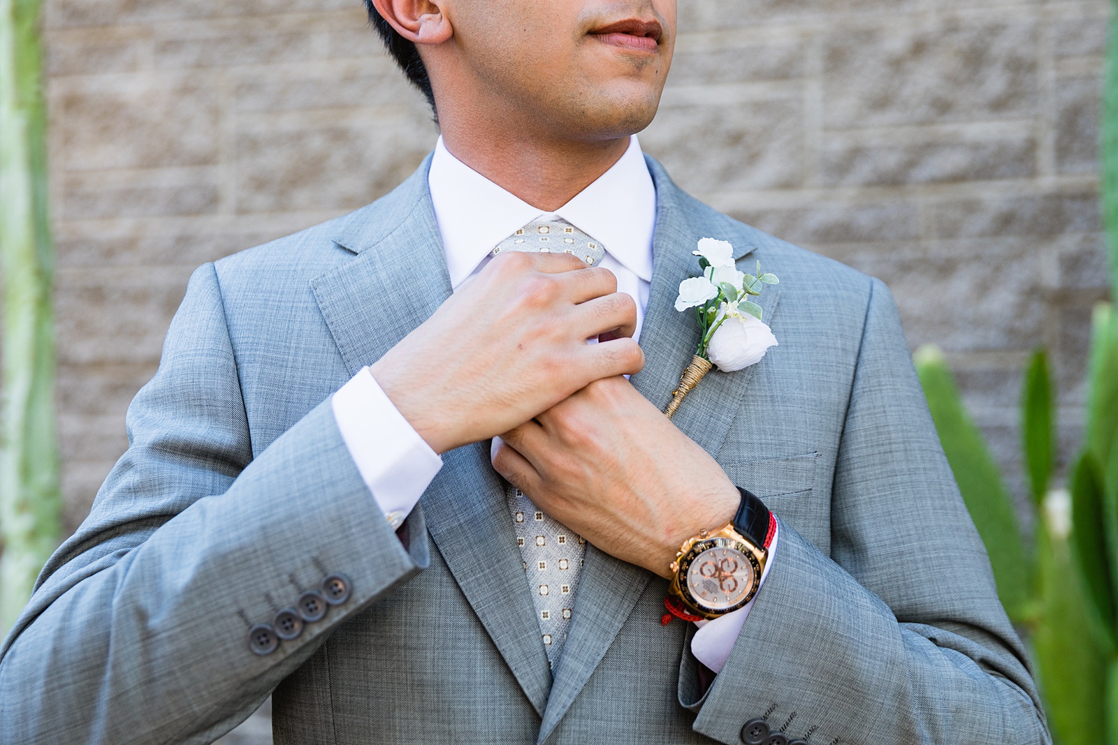Groom adjusting his tie for his wedding day by Scottdsale wedding photographers PMA Photography.