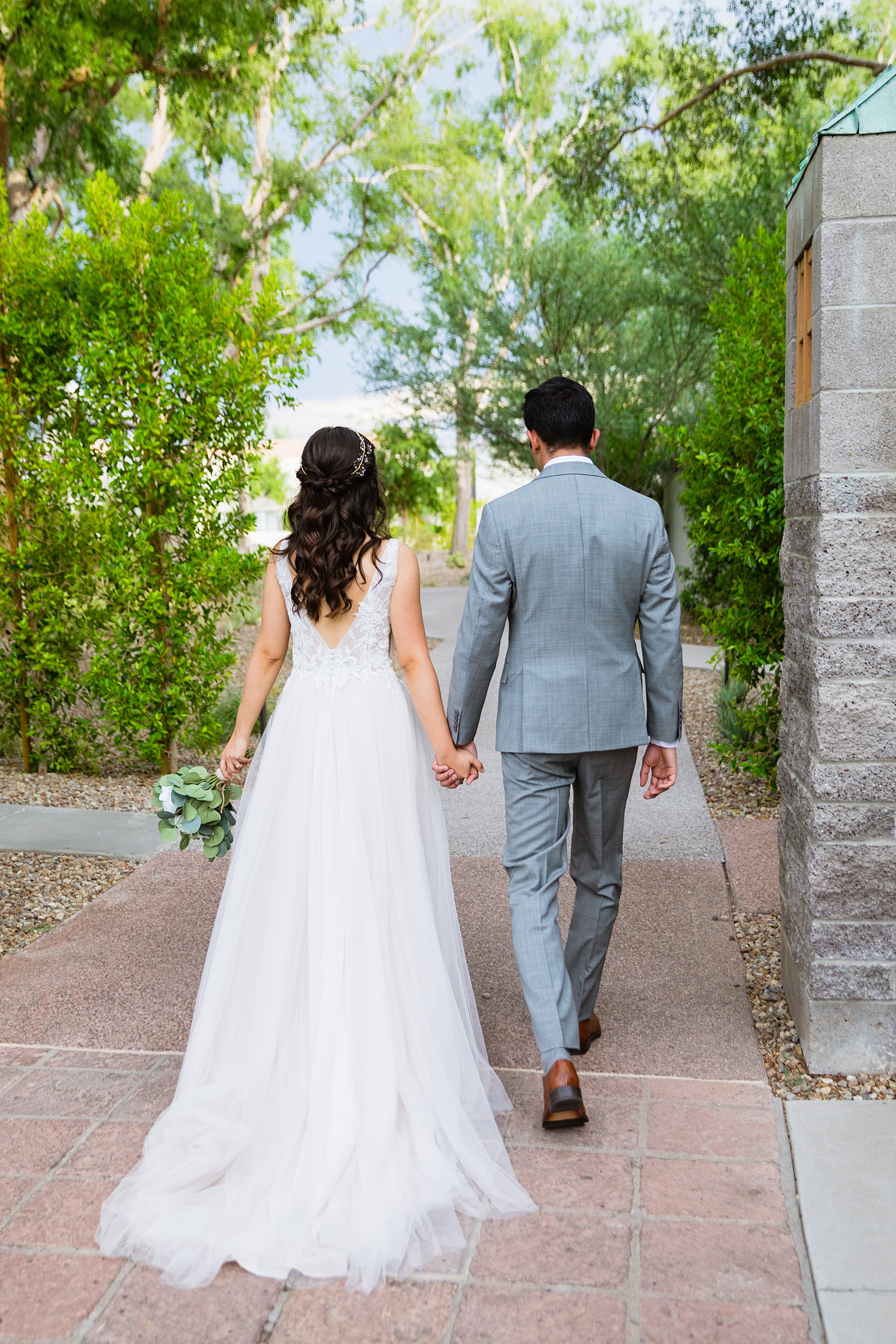 Bride and groom walking together during their Hyatt Regency Scottsdale Resort & Spa At Gainey Ranch wedding by Arizona wedding photographer PMA Photography.