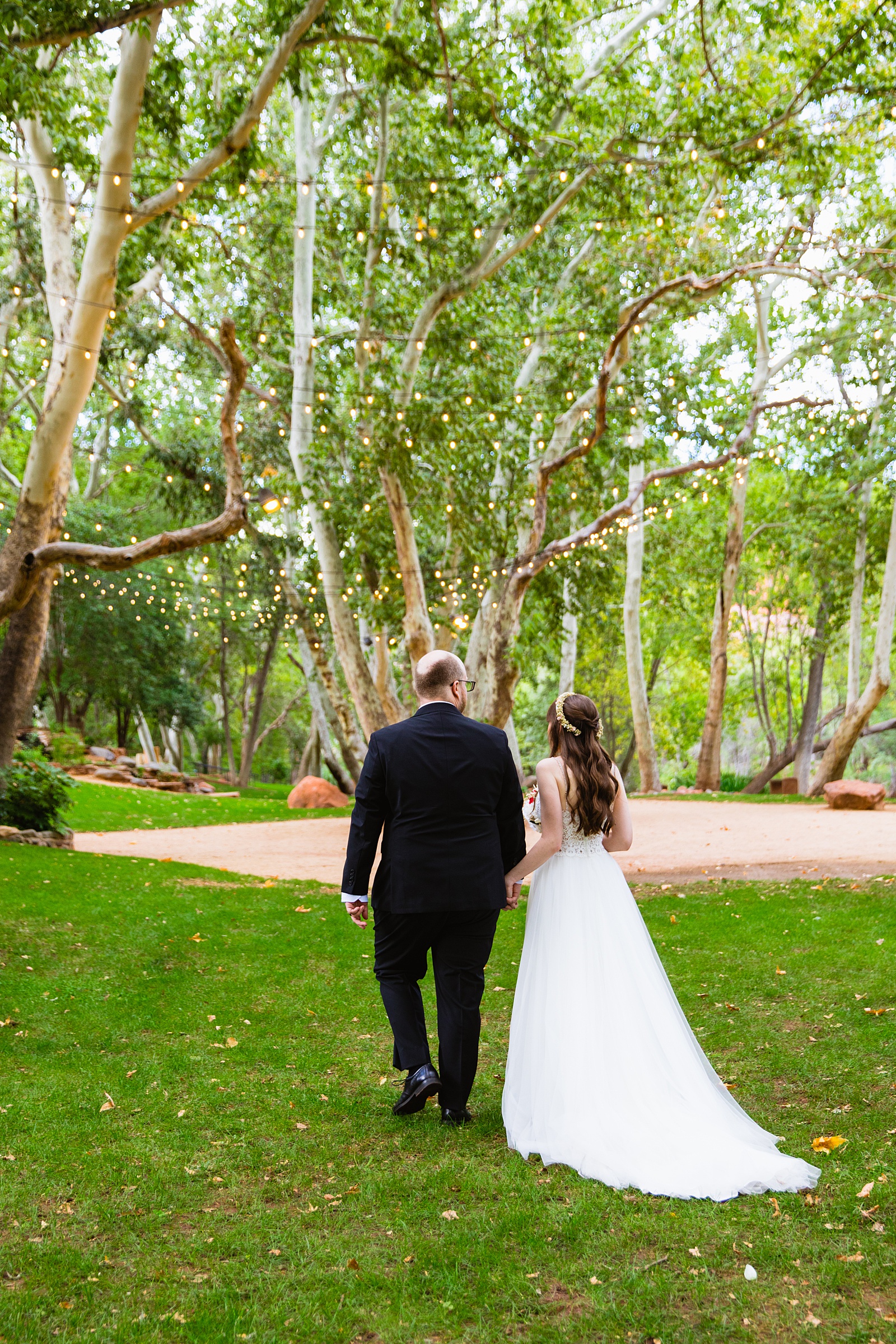 Bride and Groom walking together during their Los Abrigados wedding by Sedona wedding photographer PMA Photography.