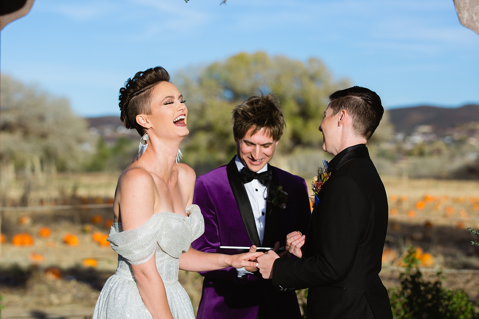 Same sex couple exchange rings during their wedding ceremony at Mortimer Farms by Arizona wedding photographer PMA Photography.