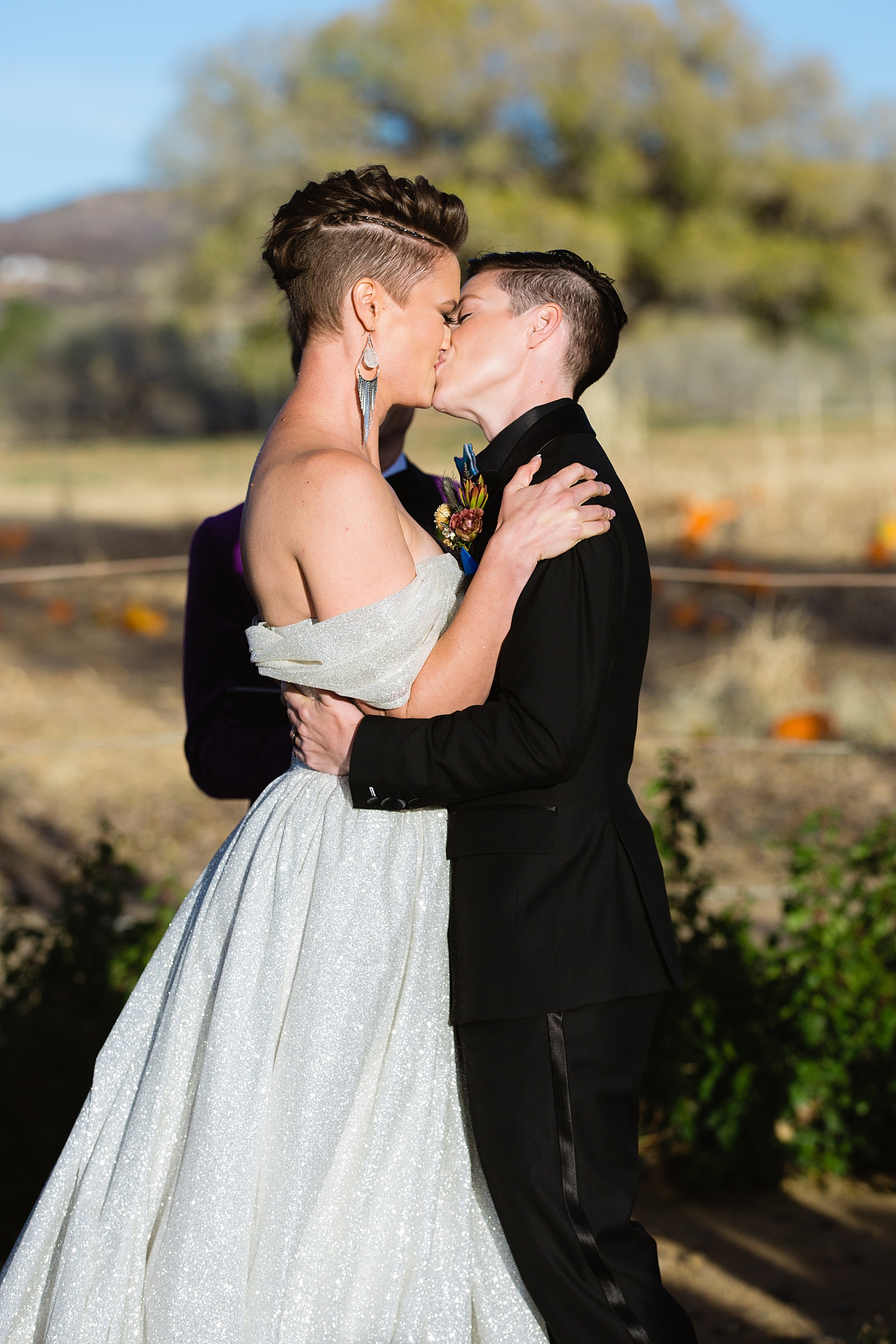 Same sex couple share their first kiss during their wedding ceremony at Mortimer Farms by Arizona wedding photographer PMA Photography.