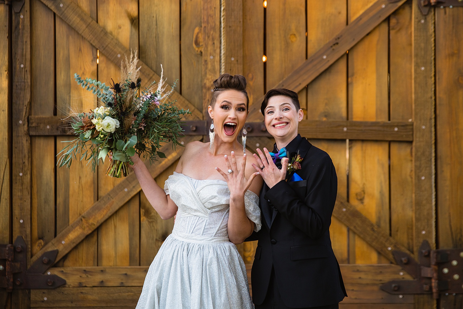 We did it! Same sex couple pose during their Mortimer Farms wedding by Arizona wedding photographer PMA Photography.