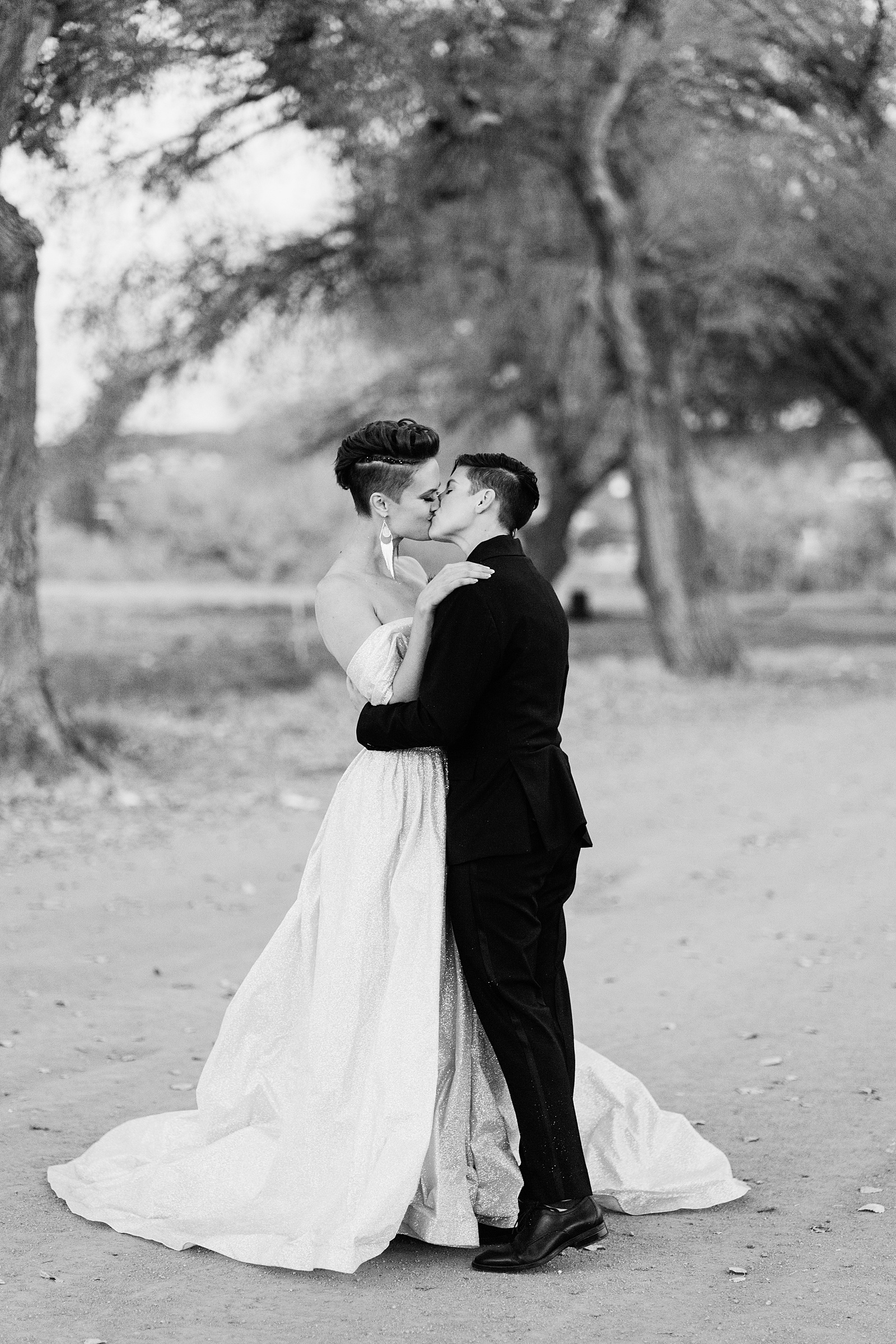 Same sex couple share a kiss during their Mortimer Farms wedding by Arizona wedding photographer PMA Photography.
