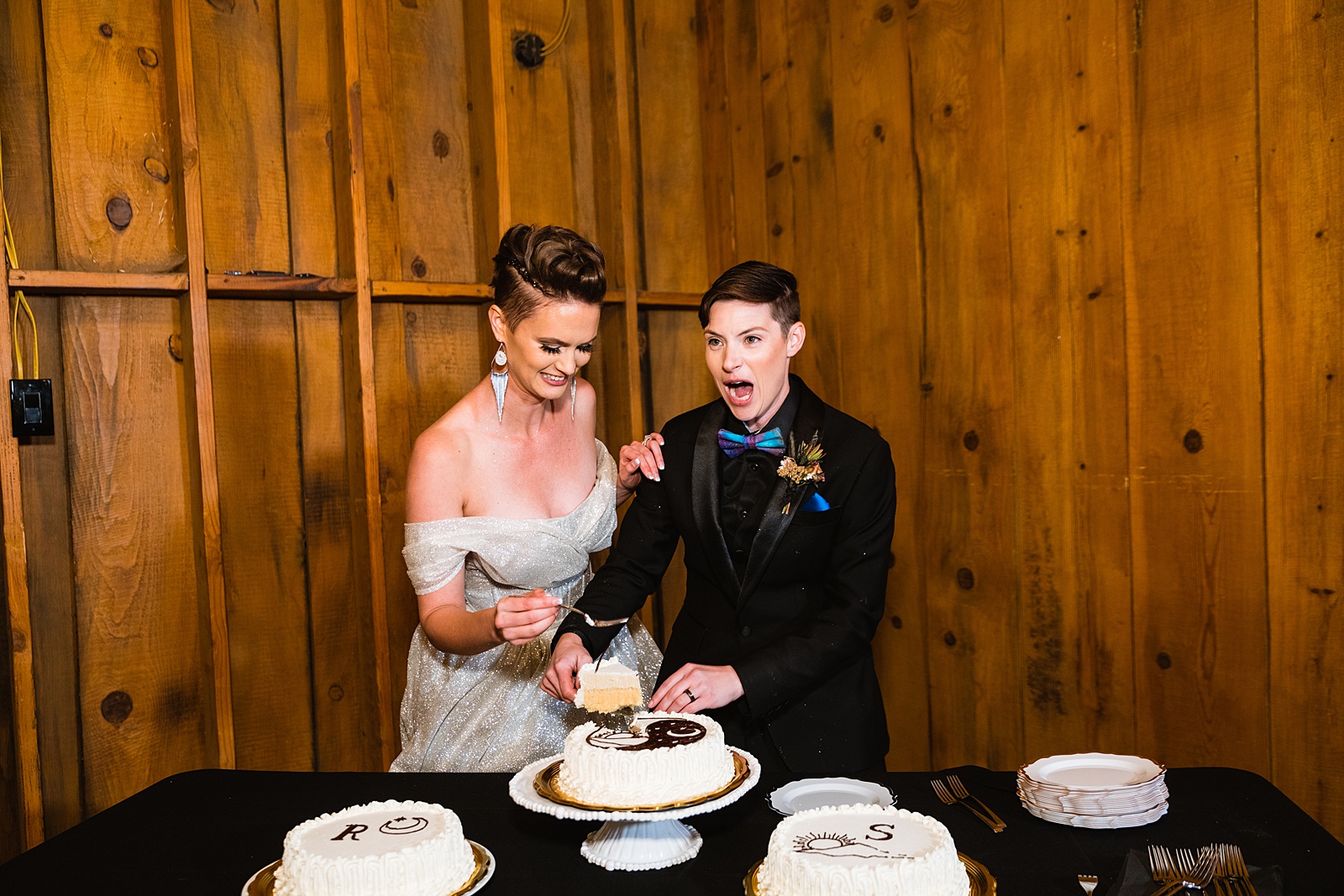 Same sex couple cutting their wedding cake at their Mortimer Farms wedding reception by Arizona wedding photographer PMA Photography.