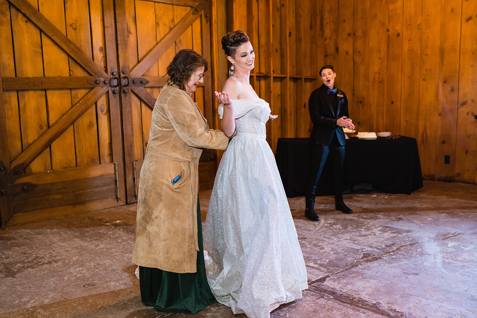 Bride changes out of wedding dress into wedding suit before first dance at Mortimer Farms wedding reception by Prescott wedding photographer PMA Photography