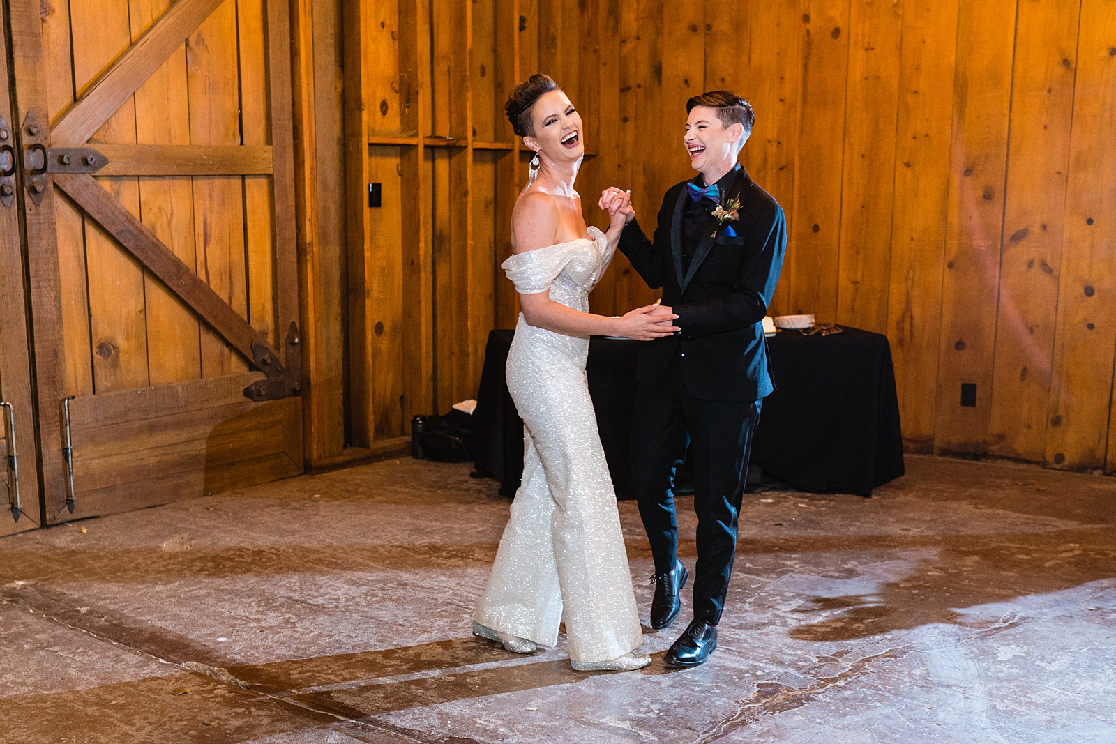 Bride changes out of wedding dress into wedding suit before first dance at Mortimer Farms wedding reception by Prescott wedding photographer PMA Photography