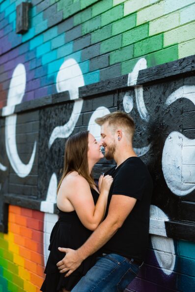 Couple laugh together during their Roosevelt Row engagement session by Phoenix engagement photographer PMA Photography.