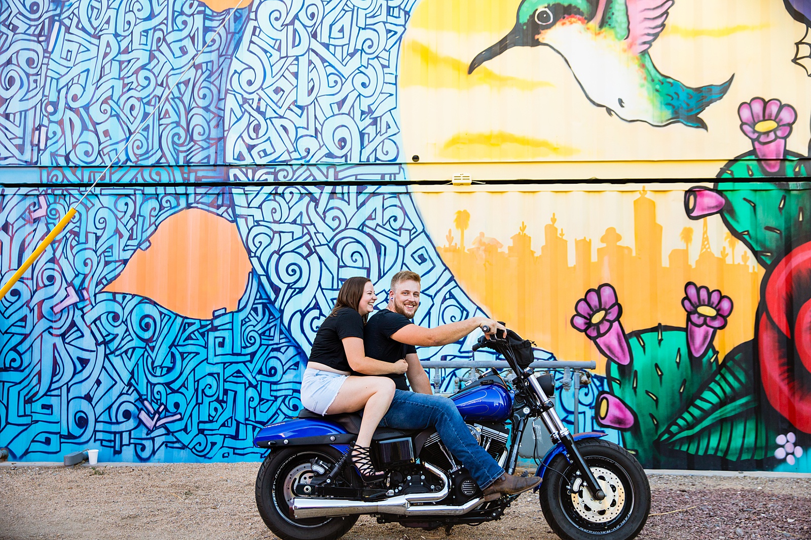 Adventurous couple pose on their motorcycle during their Phoenix engagement session by Arizona wedding photographer PMA Photography.