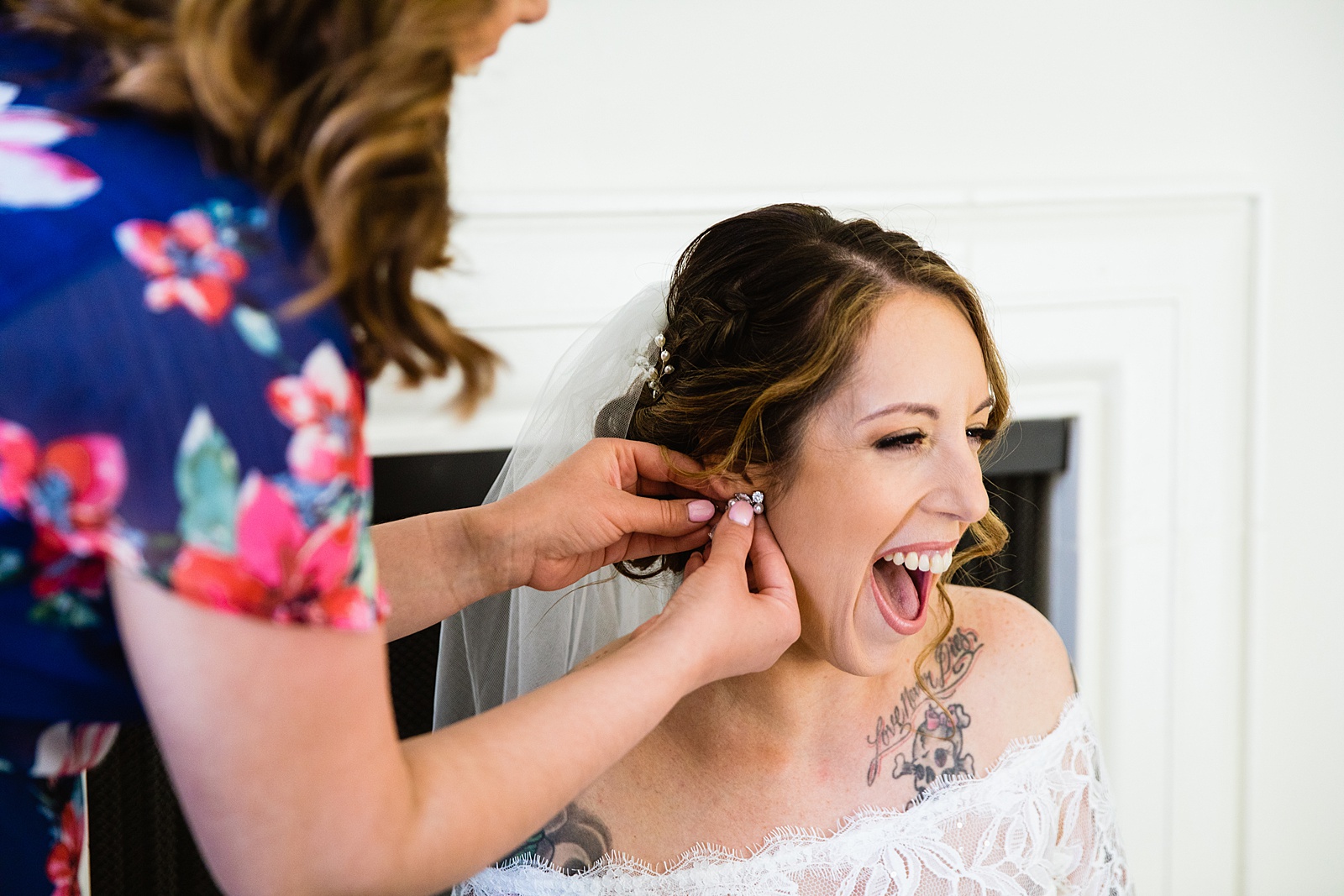 Bride adjusting her earrings on her wedding day by Scottsdale wedding photographers PMA Photography.