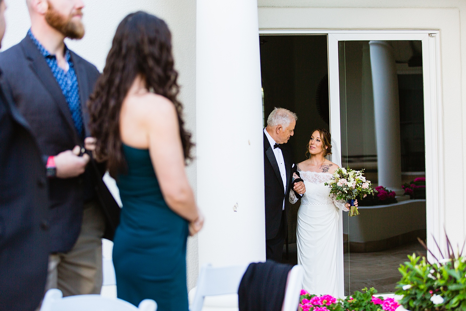 Bride walking down aisle during backyard wedding ceremony by Phoenix wedding photographer PMA Photography.