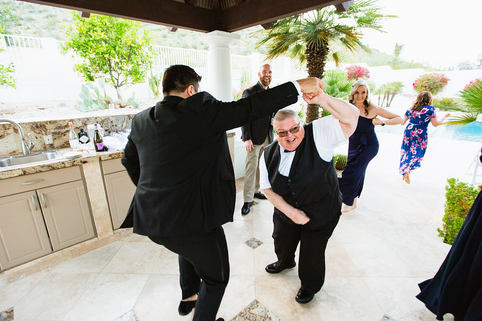 Guests dancing together at backyard wedding reception by Scottsdale wedding photographer PMA Photography