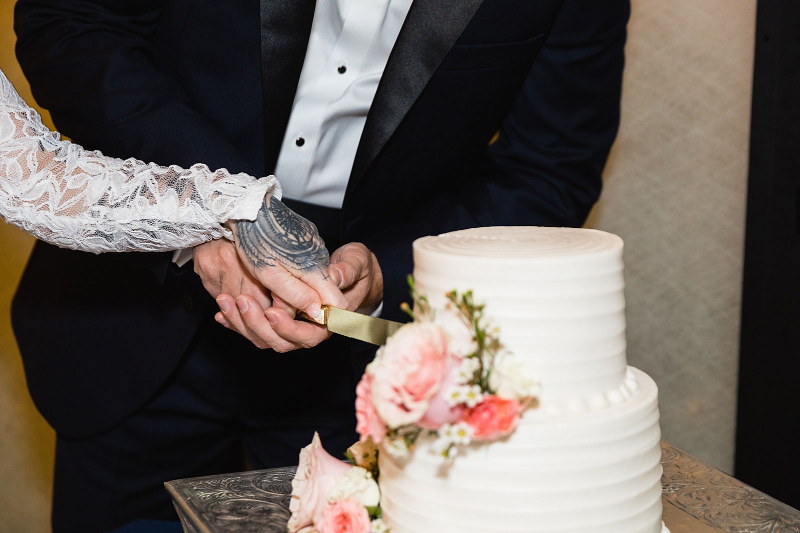 Bride and groom cutting their wedding cake at their backyard wedding reception by Arizona wedding photographer PMA Photography.
