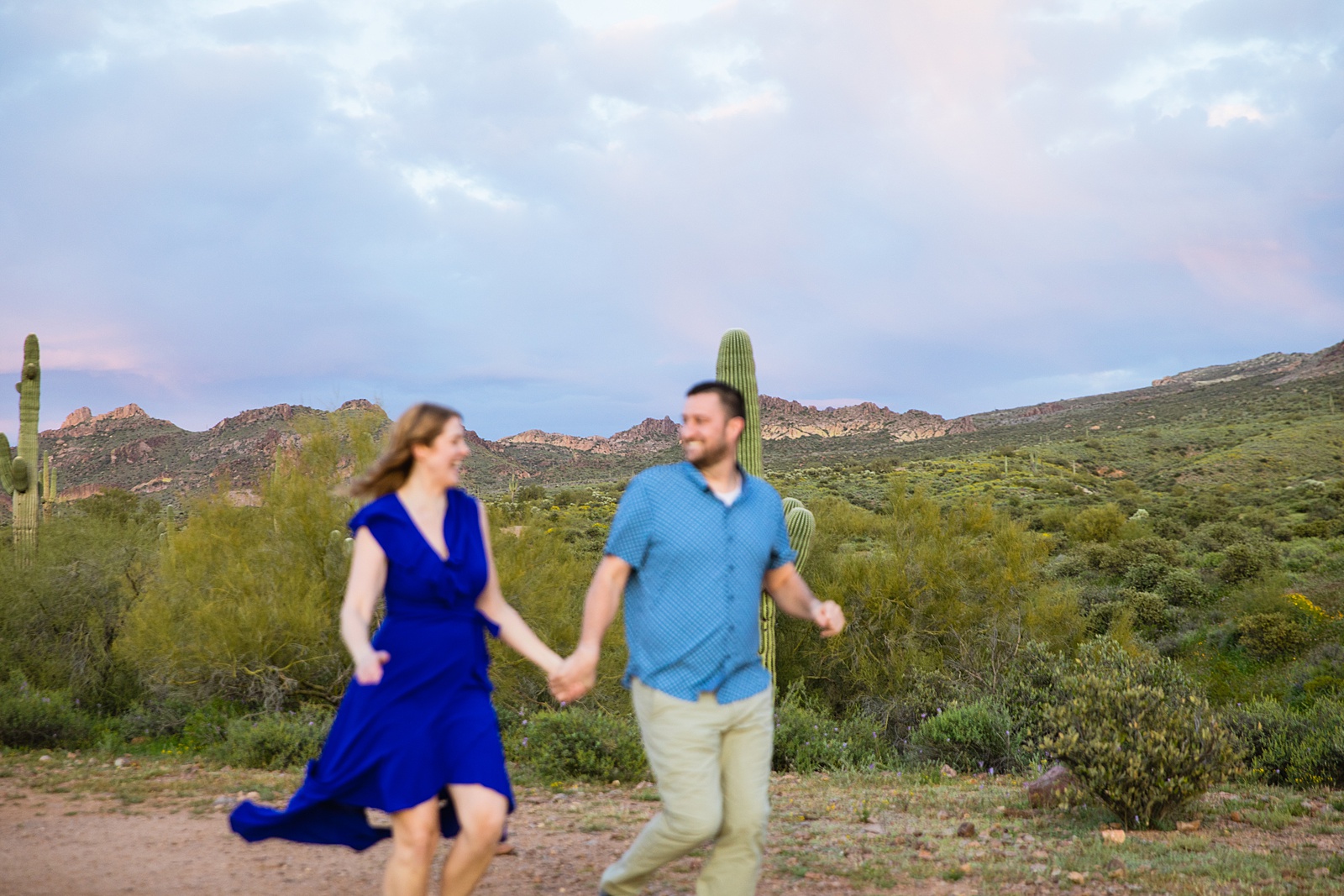 Couple having fun together during their Superstitions Mountain engagement session by Apache Junction engagement photographer PMA Photography.