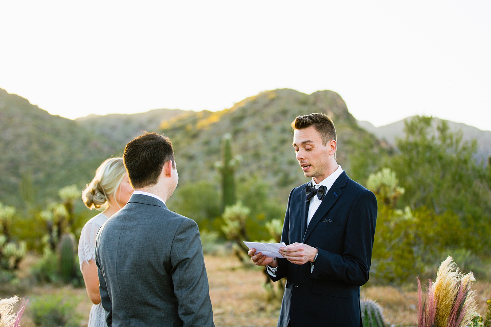 LGBTQ couple exchange vows during their wedding ceremony at White Tanks by Arizona elopement photographer PMA Photography.