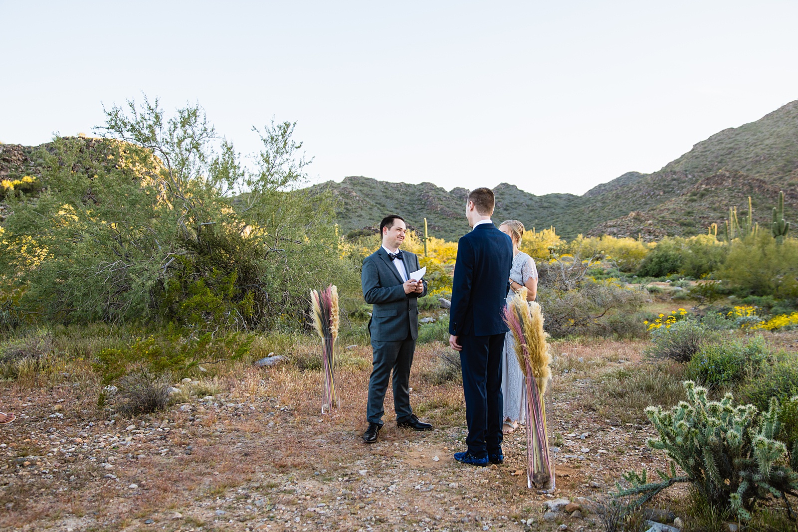 Same sex couple exchange vows during their wedding ceremony at White Tanks by Arizona elopement photographer PMA Photography.