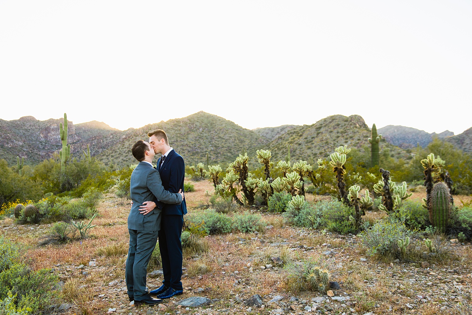 Same sex couple share a kiss during their White Tanks elopement by Arizona elopement photographer PMA Photography.
