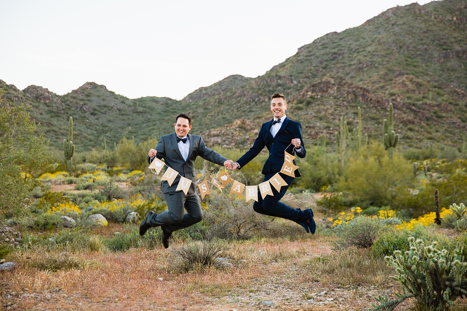 LGBTQ couple jumping together as newlyweds by PMA Photography.