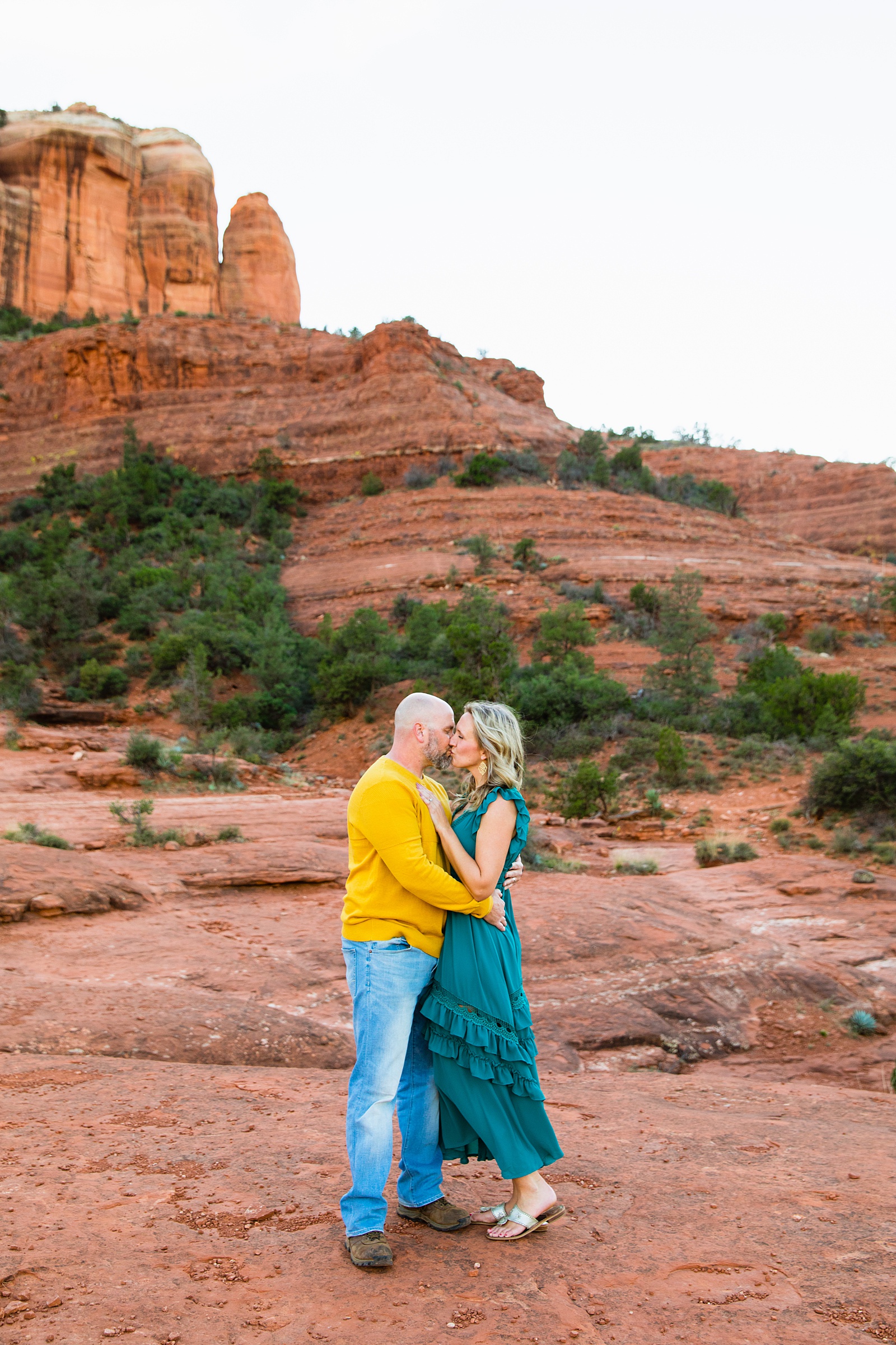 Parents share a kiss during their Sedona family session by Arizona family photographer PMA Photography.