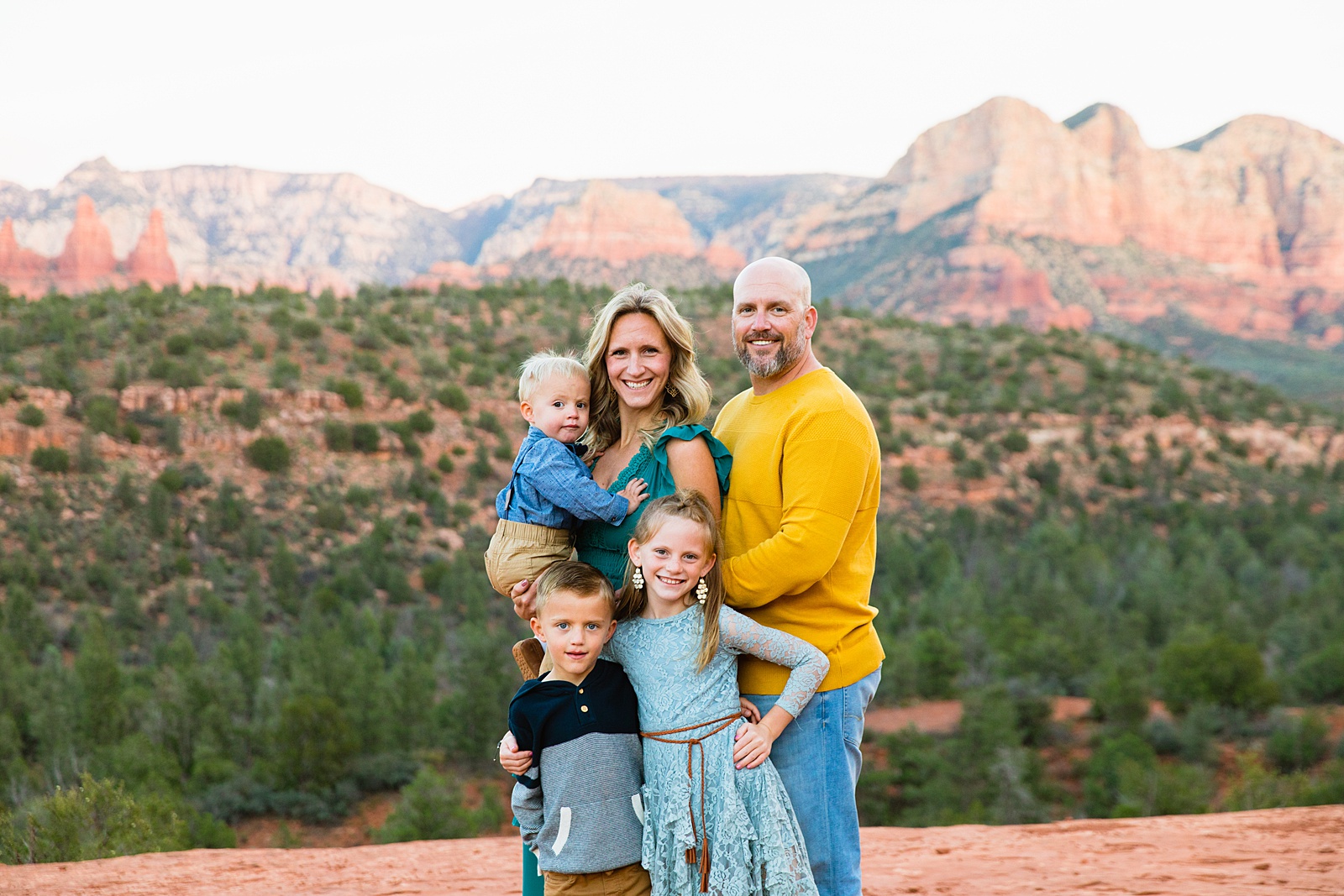 Family pose for their Cathedral Rock family session by Sedona family photographer PMA Photography.