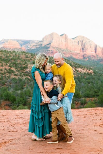Family laughing together during their Cathedral Rock family session by Sedona family photographer PMA Photography.