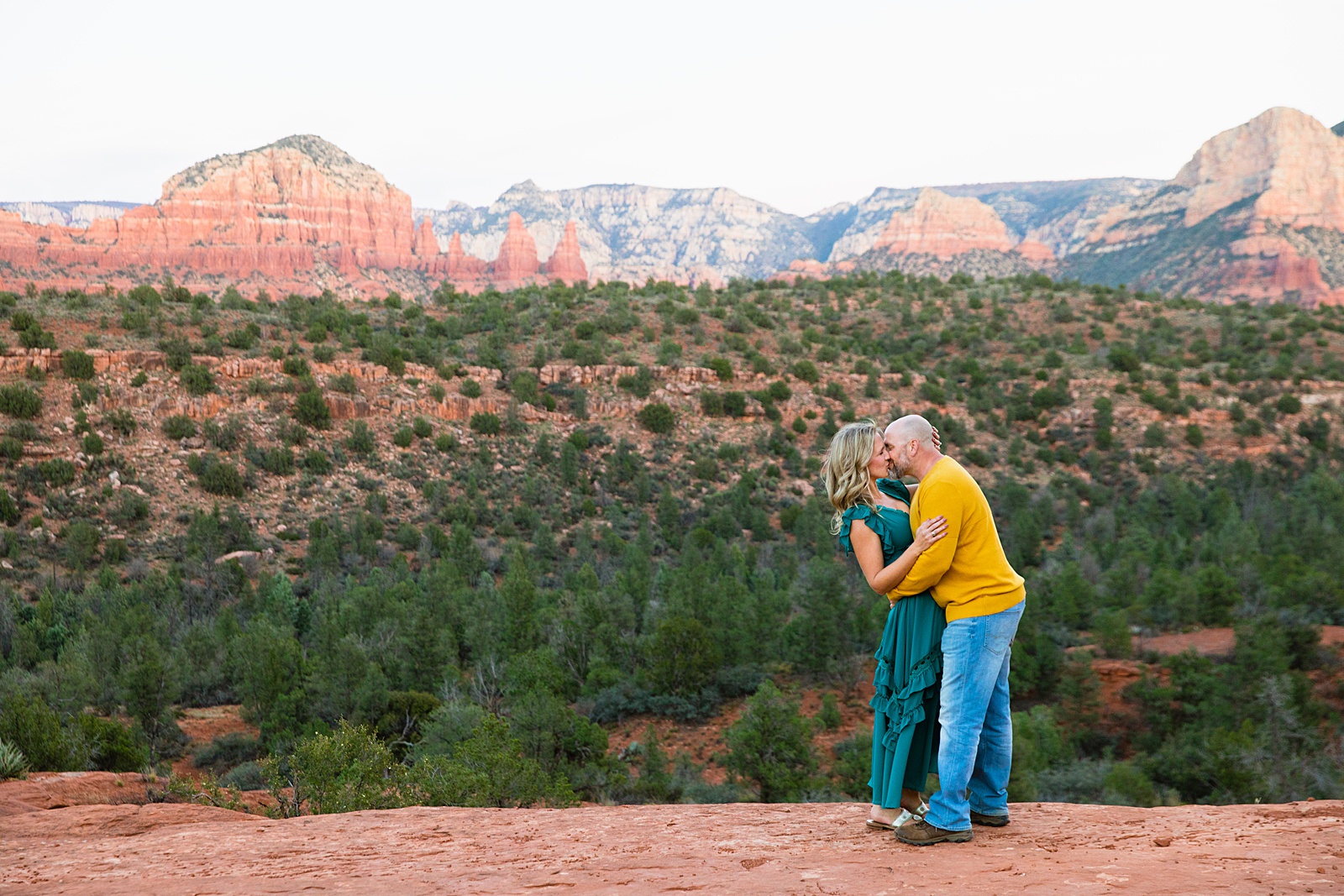 Parents share a kiss during their Sedona family session by Arizona family photographer PMA Photography.