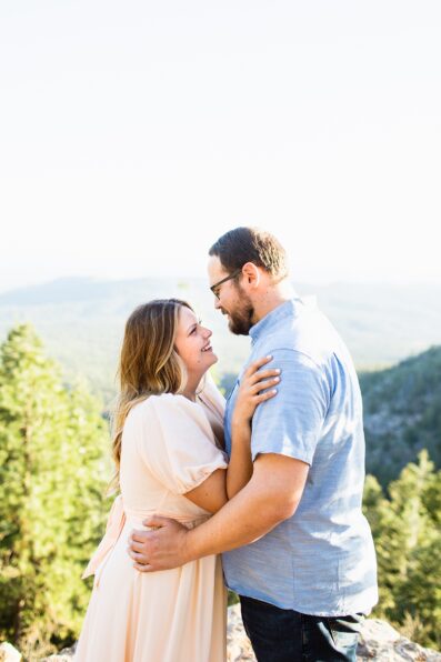Adventurous couple look at each other during their Mogollon Rim engagement session by Payson wedding photographer PMA Photography.