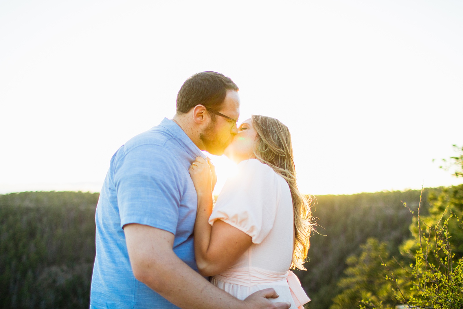 Adventurous couple share a kiss during their Payson engagement session by Arizona wedding photographer PMA Photography.