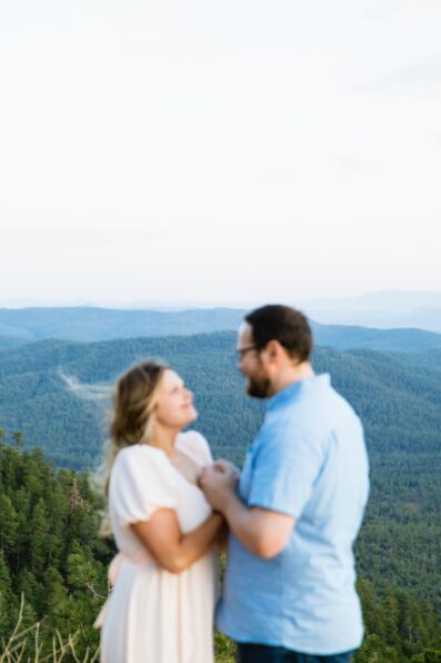 Couple look at each other during their Mogollon Rim engagement session by Payson wedding photographer PMA Photography.