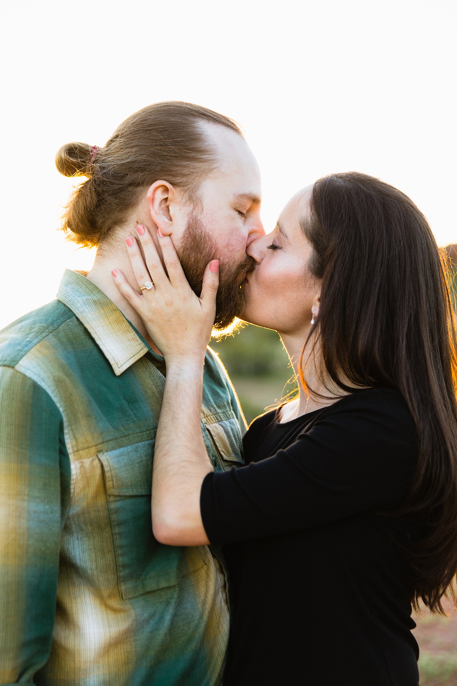 Couple share a kiss during their Papago Park engagement session by Tempe wedding photographer Juniper and Co Photography.