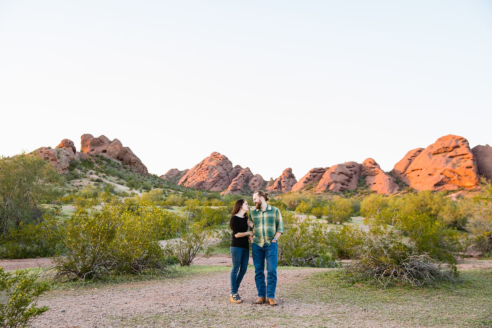 Adventurous couple look at each other during their Tempe engagement session by Arizona wedding photographer Juniper and Co Photography.