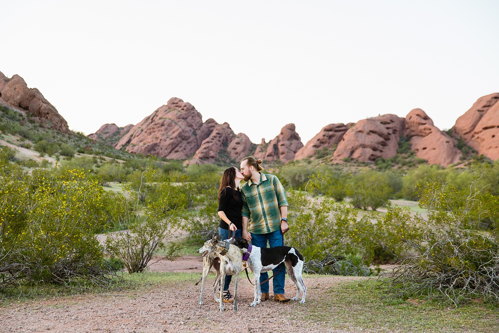 Couple share a kiss during their Papago Park engagement session by Tempe wedding photographer Juniper and Co Photography.