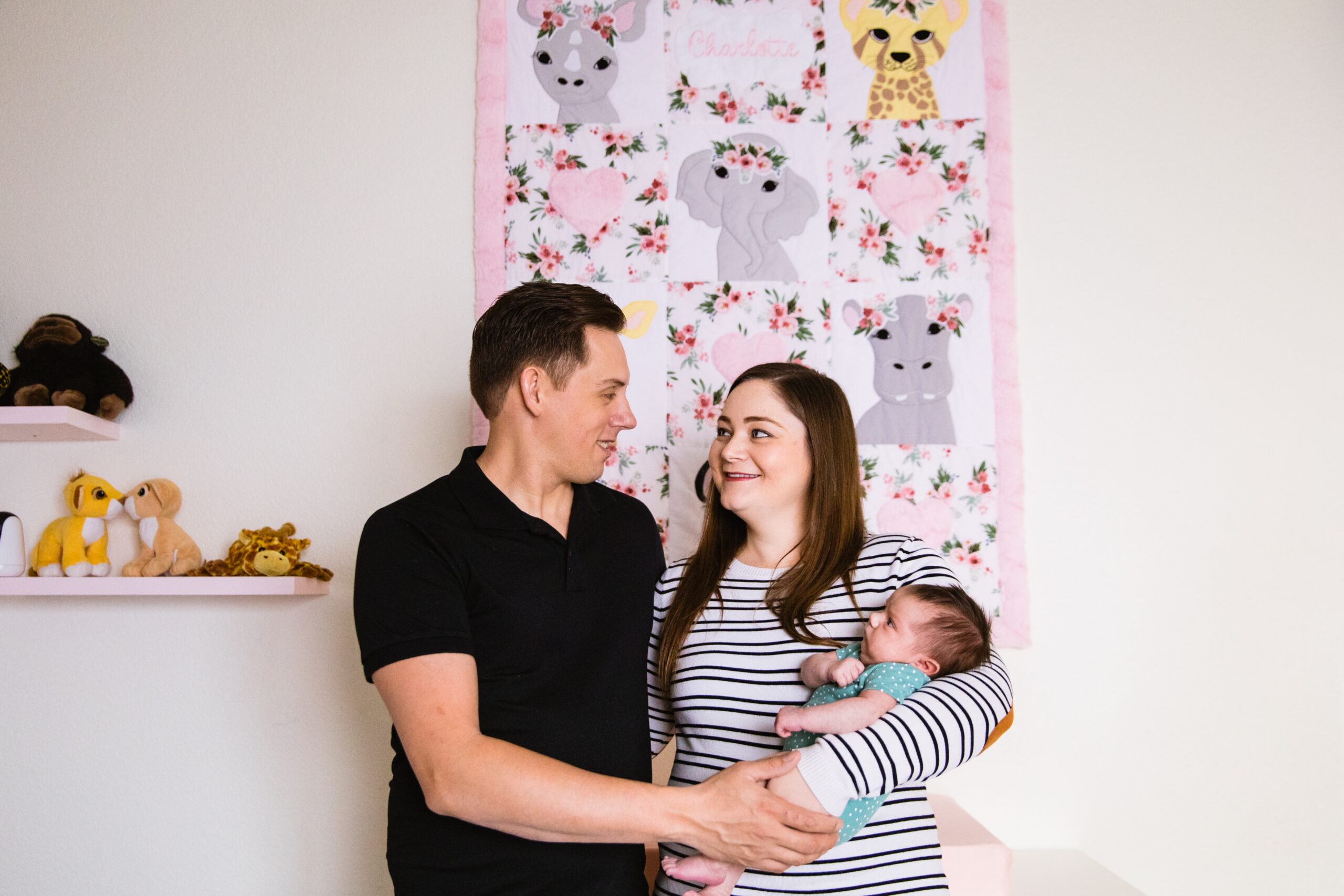 Parents pose with their daughter during Phoenix In-Home Newborn session by Arizona wedding photographer Juniper and Co Photography.