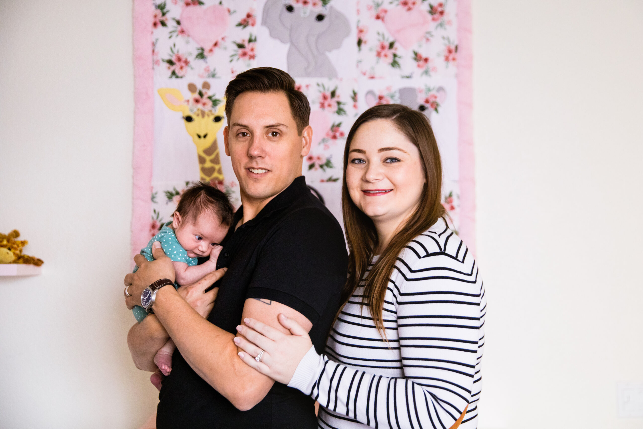 Parents pose with their daughter during Phoenix In-Home Newborn session by Arizona wedding photographer Juniper and Co Photography.