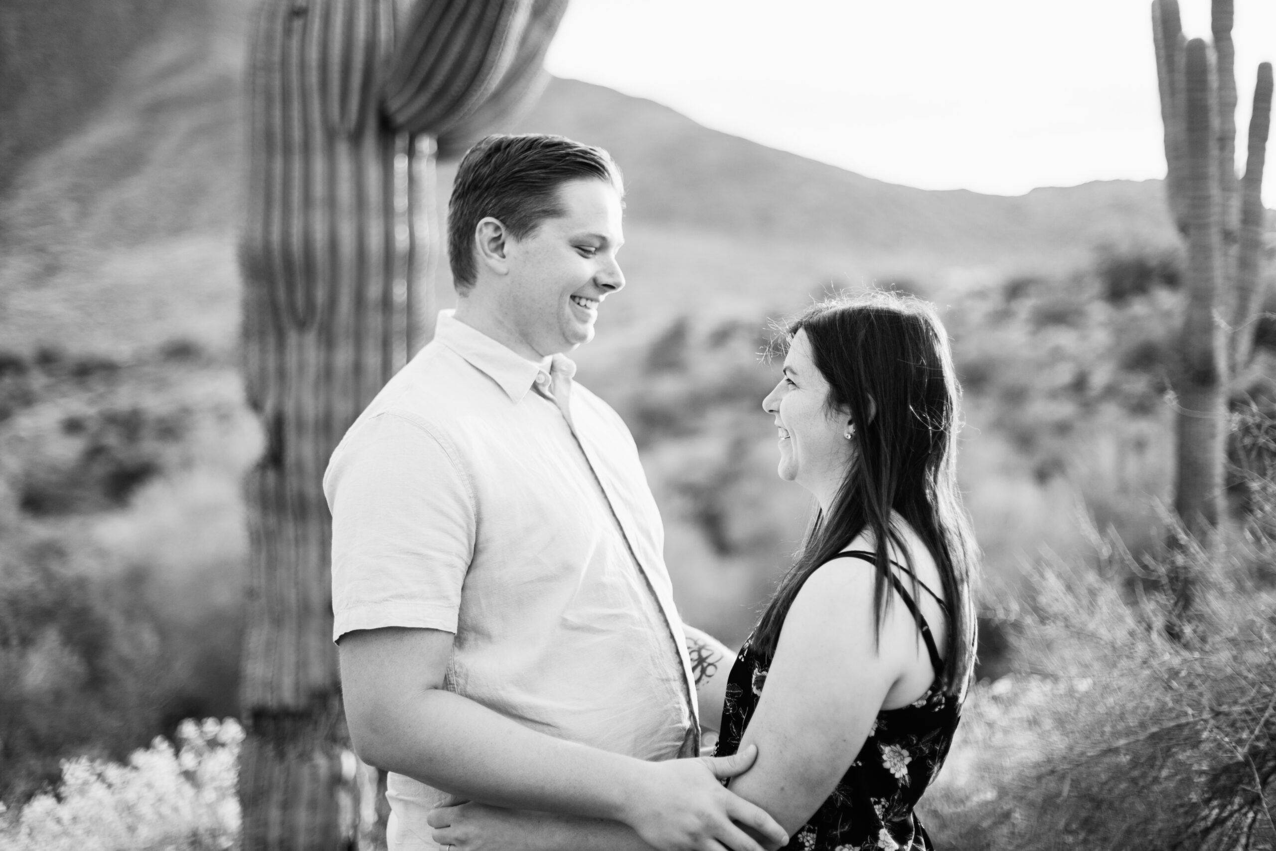 Couple look at each other during their Arizona engagement session by Arizona wedding photographer Juniper and Co Photography.