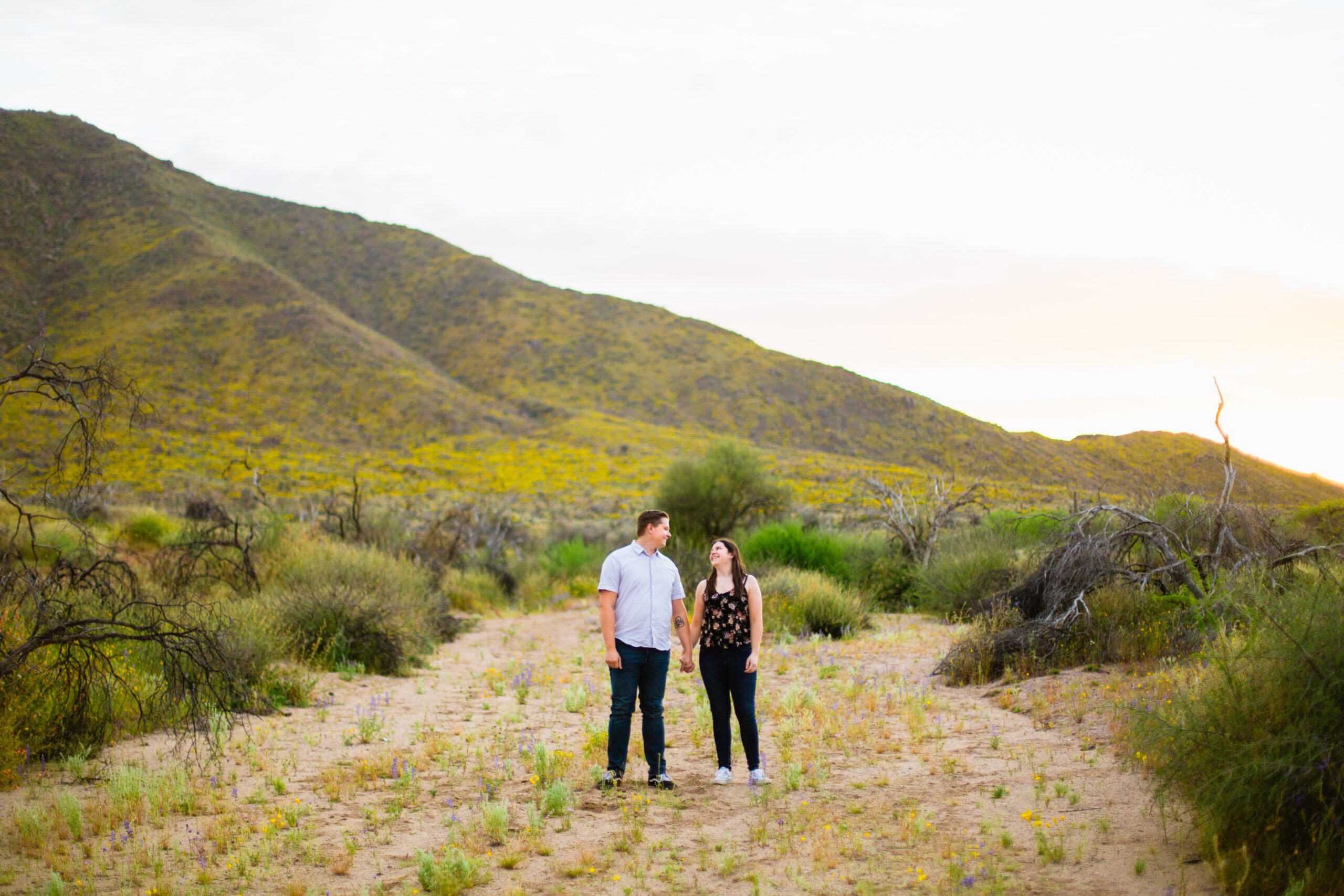 Boho couple walking together during their Arizona engagement session by Arizona engagement photographer Juniper and Co Photography.