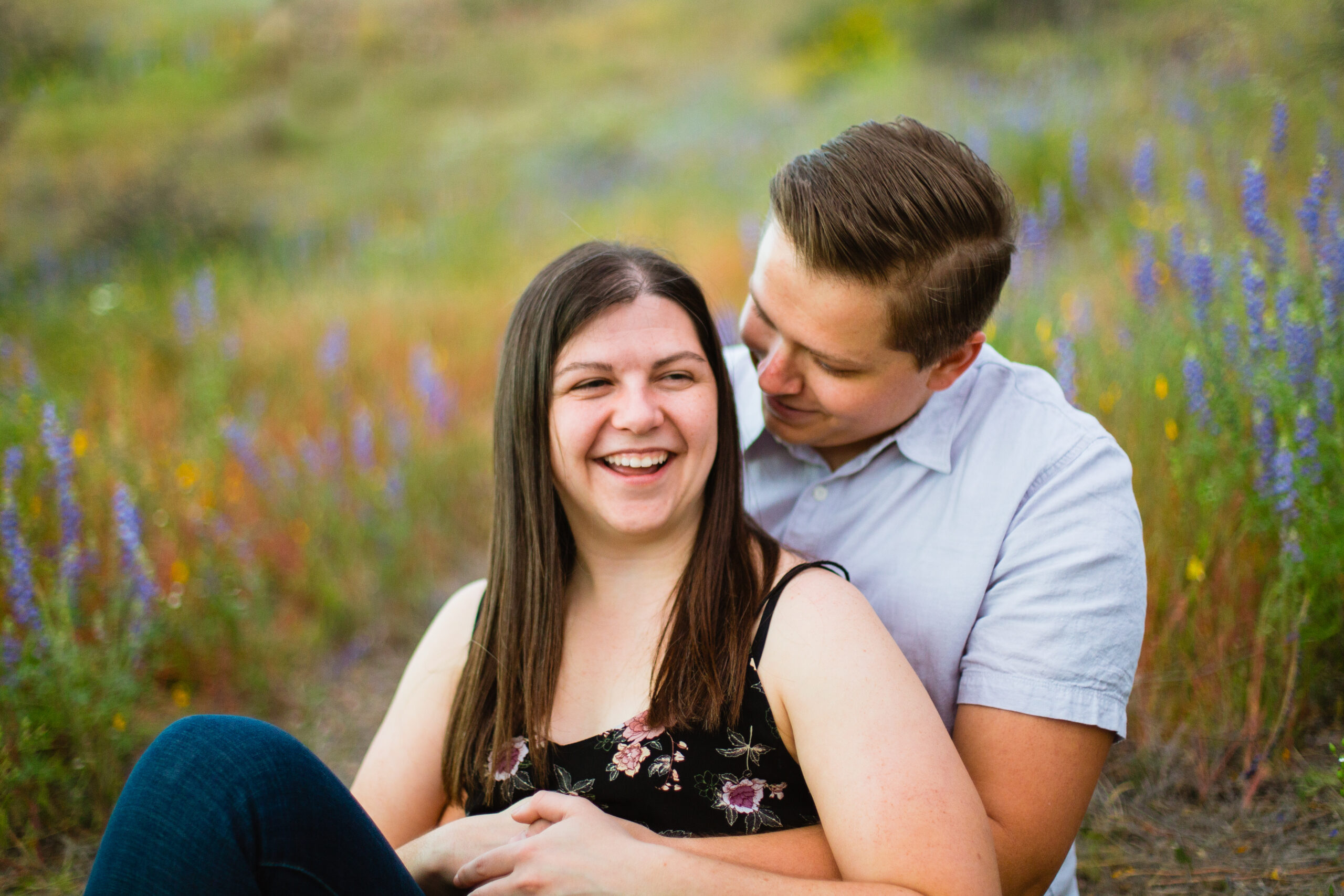 Couple laugh together during their Arizona engagement session by Arizona engagement photographer Juniper and Co Photography.