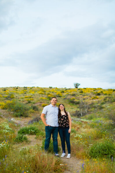 Couple pose for their desert wildflower engagement session by Arizona wedding photographer Juniper and Co Photography.
