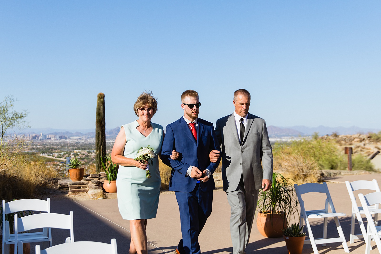 Groom walking down aisle during desert wedding ceremony by Phoenix wedding photographer Juniper and Co Photography.