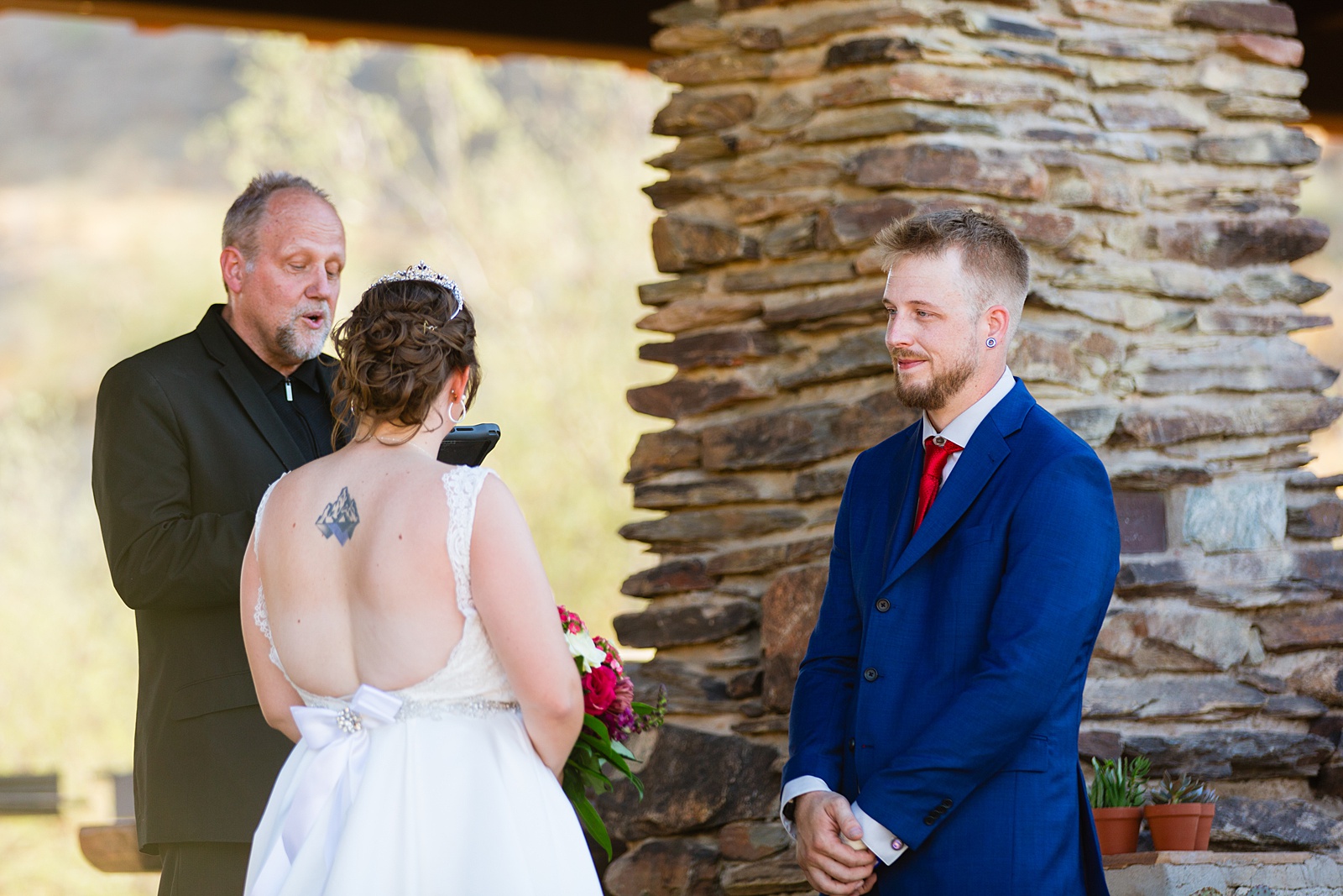 Groom looking at his bride during their wedding ceremony at intimate desert by Phoenix wedding photographer Juniper and Co Photography.