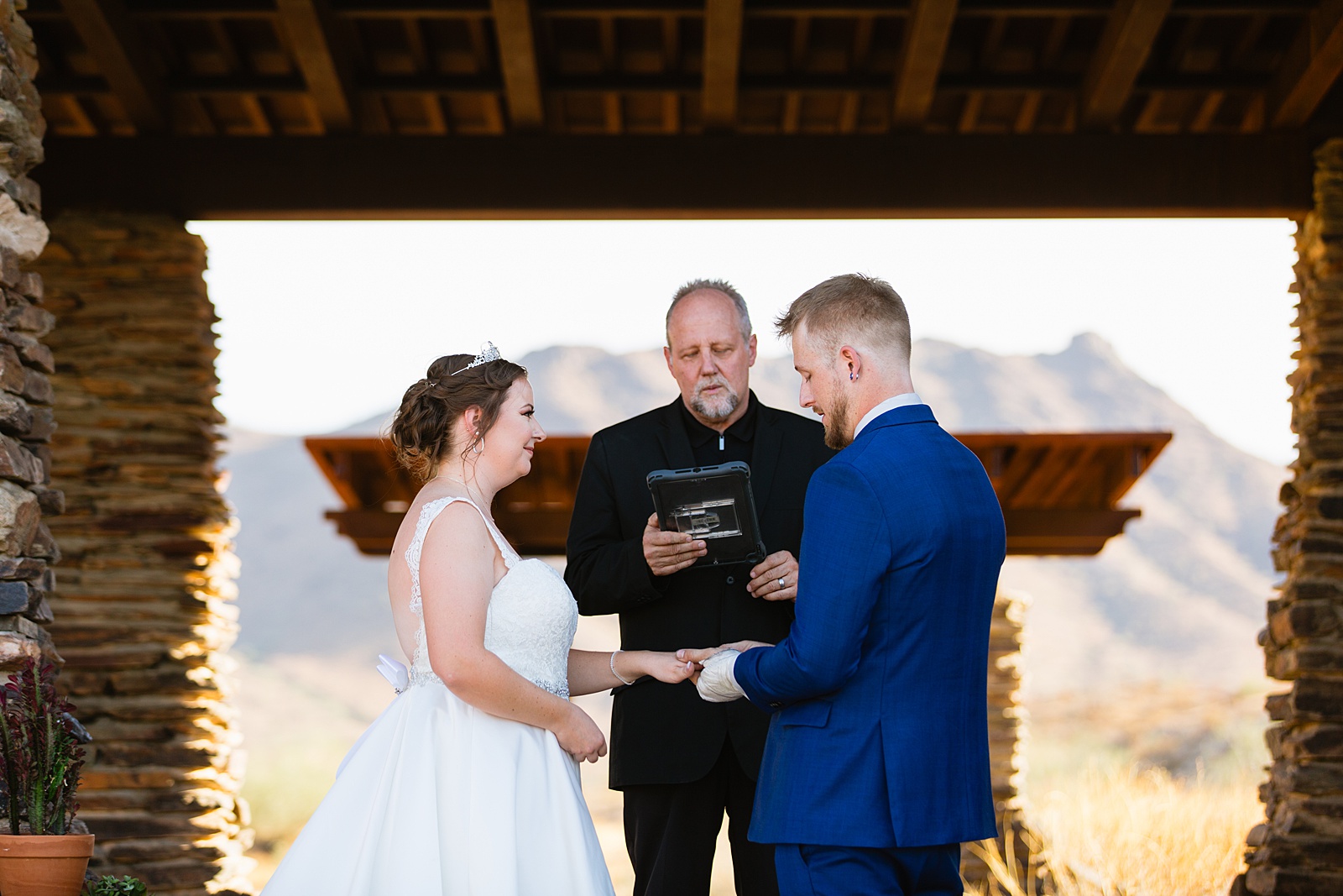 Bride and groom exchange rings during their wedding ceremony at intimate desert wedding by Phoenix wedding photographer Juniper and Co Photography.