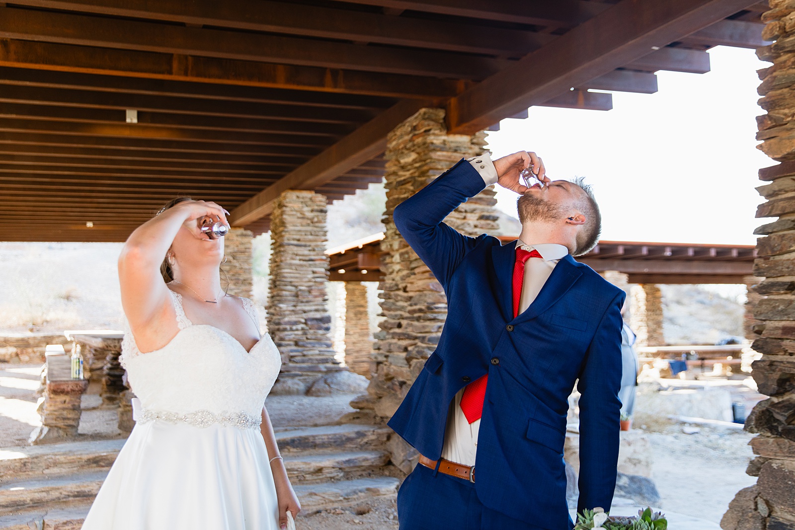 Bride and groom share shots of tequila during their intimate desert wedding ceremony by Phoenix wedding photographer Juniper and Co Photography.