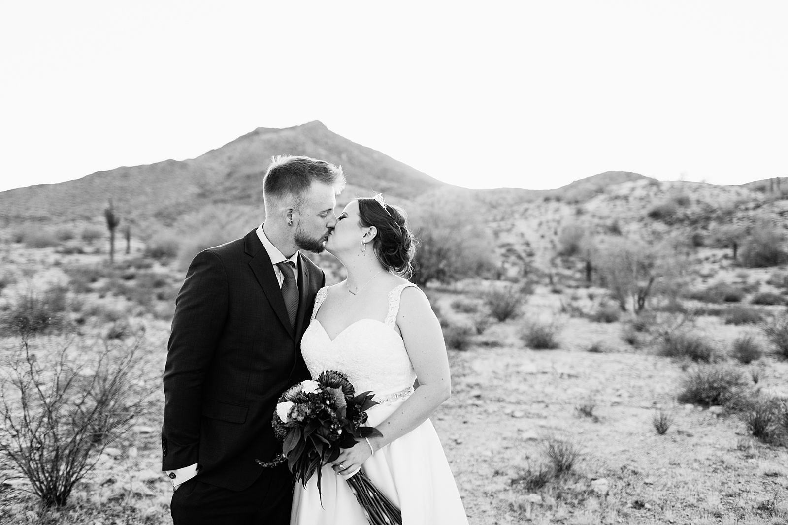 Bride and groom share a kiss during their intimate desert wedding by Phoenix wedding photographer Juniper and Co Photography.