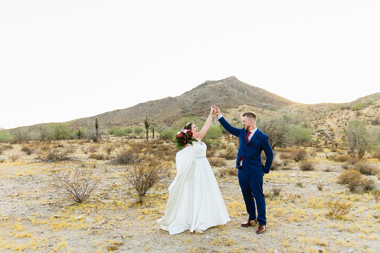 Bride and groom dance together during their intimate desert wedding by Phoenix wedding photographer Juniper and Co Photography.