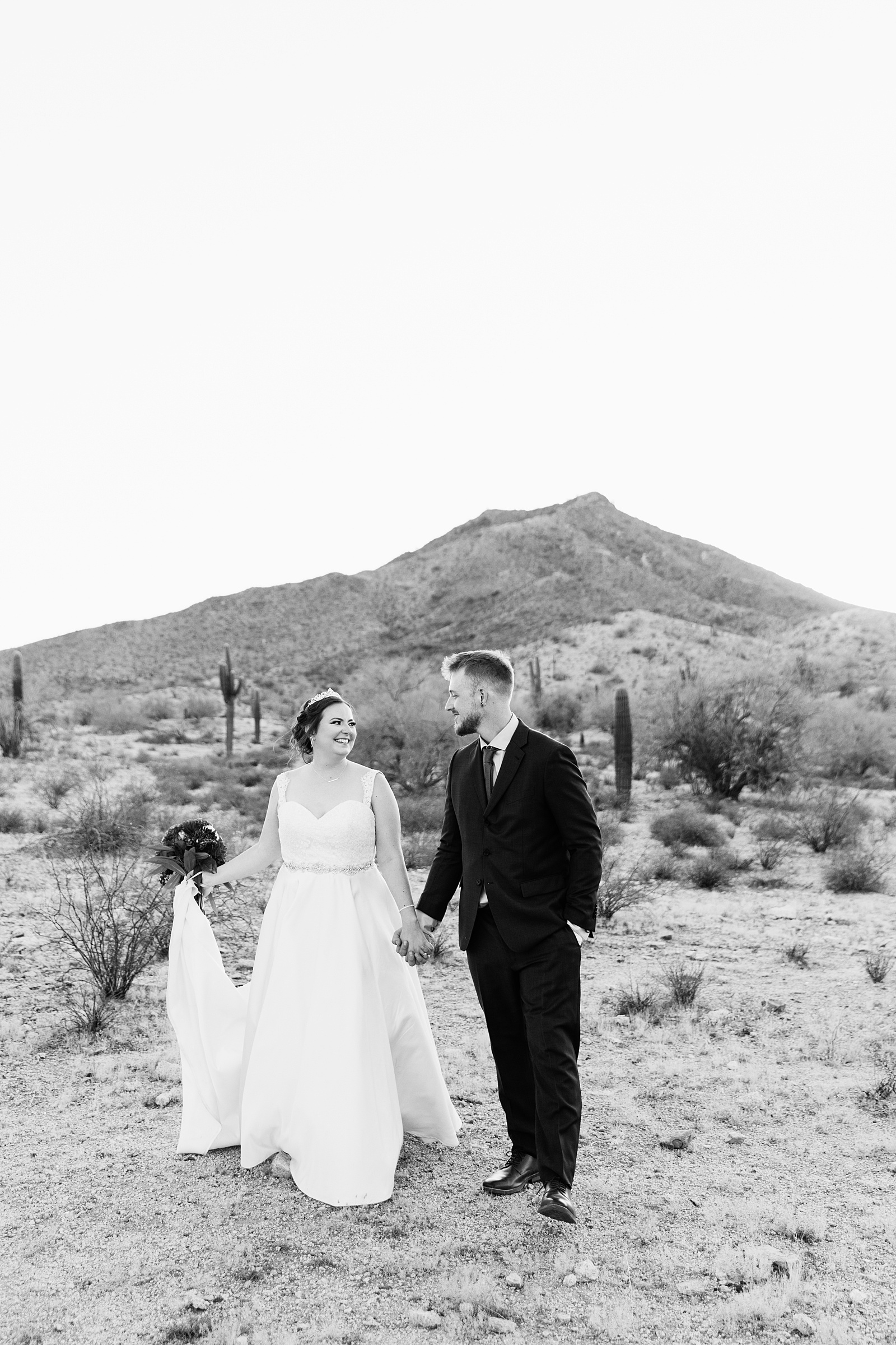 Bride and groom walking together during their intimate desert wedding by Arizona wedding photographer Juniper and Co Photography.