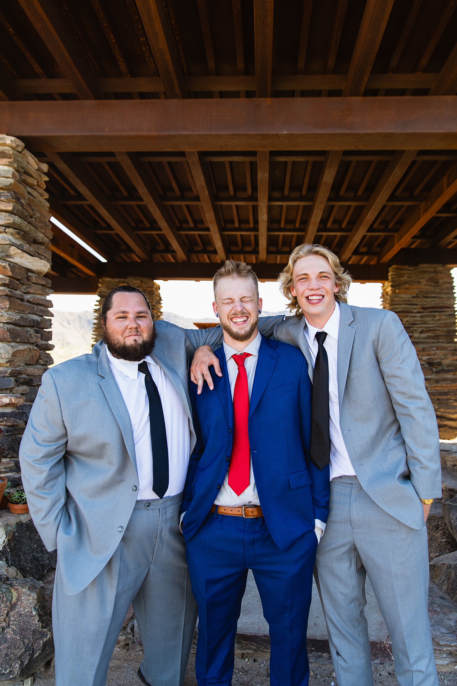 Groom and groomsmen laughing together at intimate desert wedding by Phoenix wedding photographer Juniper and Co Photography.