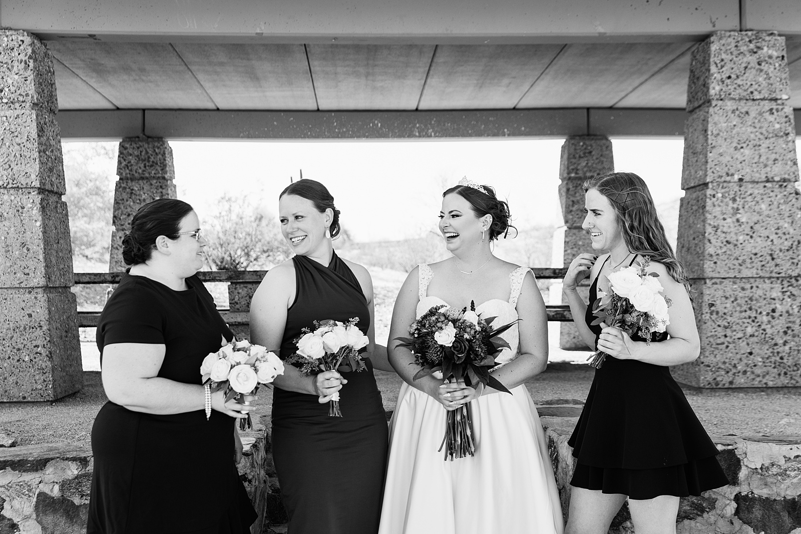 Bride and bridesmaids laughing together at intimate desert wedding by Phoenix wedding photographer Juniper and Co Photography.
