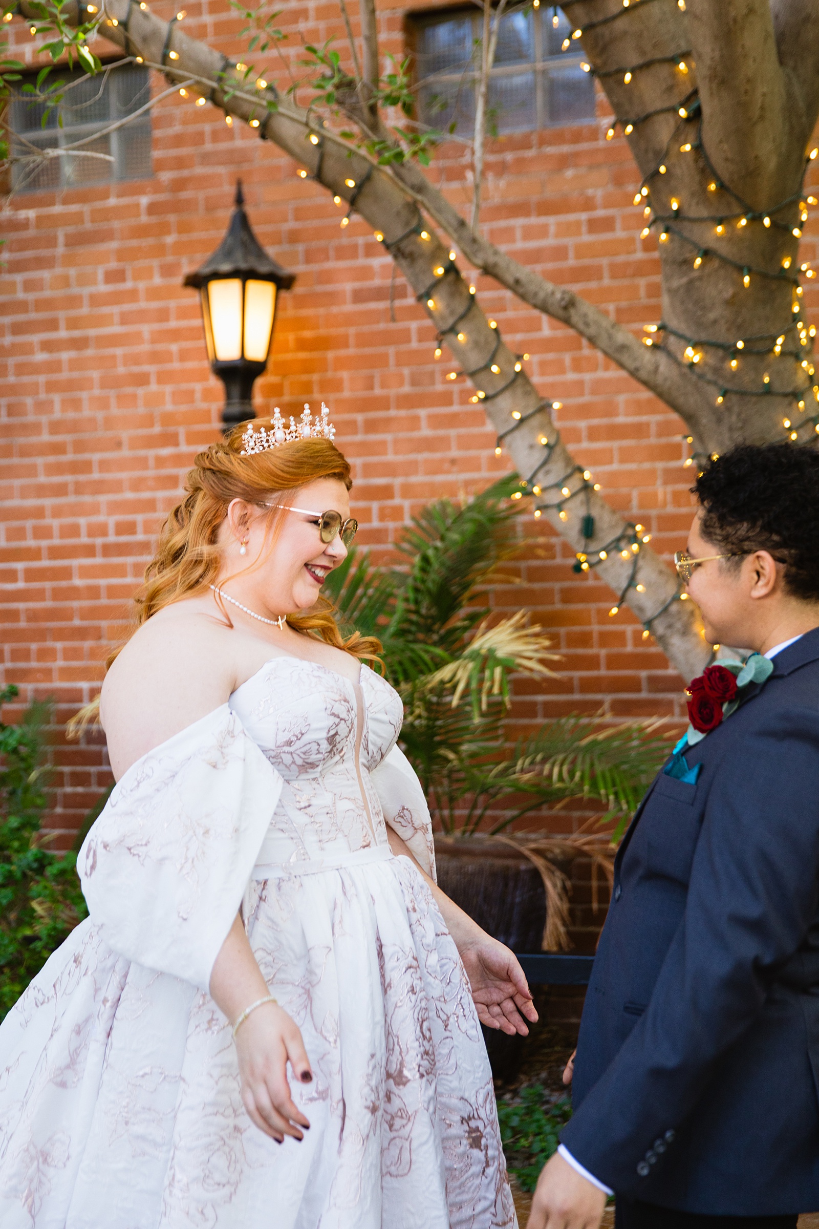Same sex couple share an intimate moment during their first look at Regency Garden by Phoenix wedding photographer Juniper and Co Photography.