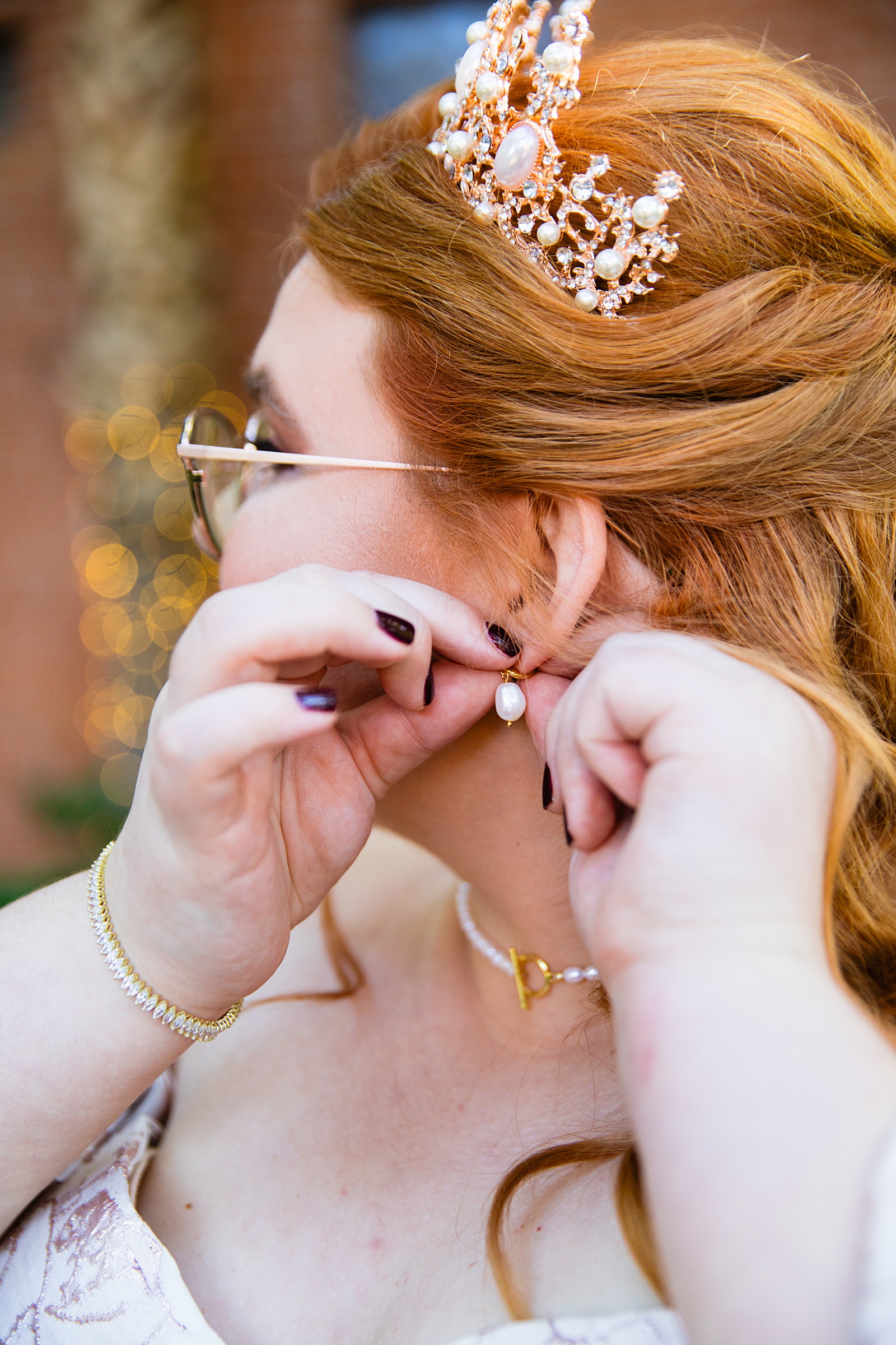 Bride adjusting her earrings on her wedding day by Mesa wedding photographers Juniper and Co Photography.