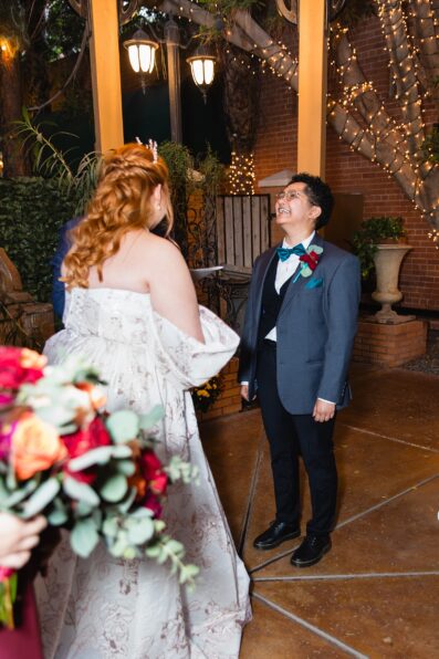 Same sex couple laughing together during their wedding ceremony at Regency Garden by Phoenix wedding photographer Juniper and Co Photography.